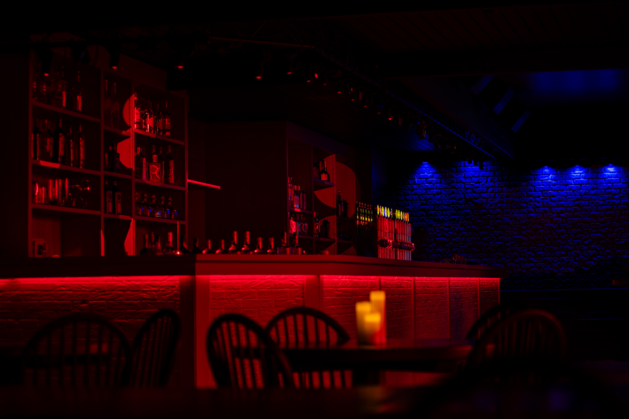 La sala e il bancone illuminati di rosso al Black Horse Pub di Cermenate